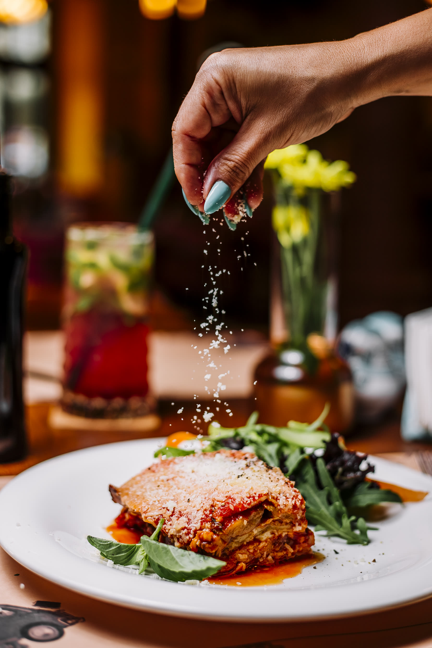 Geste du service : parmesan râpé sur des lasagnes